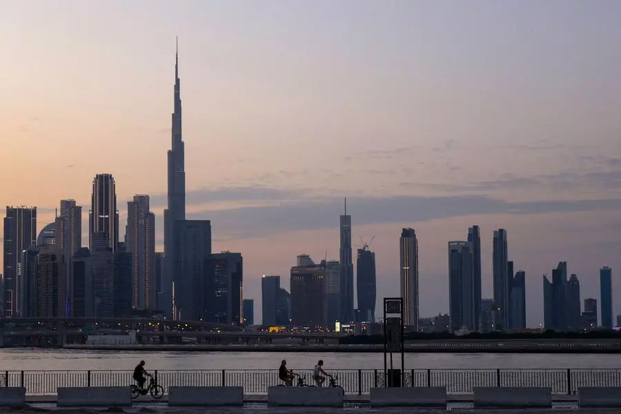 A picture shows people cycling with a general view of the Dubai skyline including Burj Khalifa, the world�s tallest building on November 24, 2023. (Photo by Karim SAHIB / AFP) Agence France-Presse (AFP)/AFP Source: Zawya.com